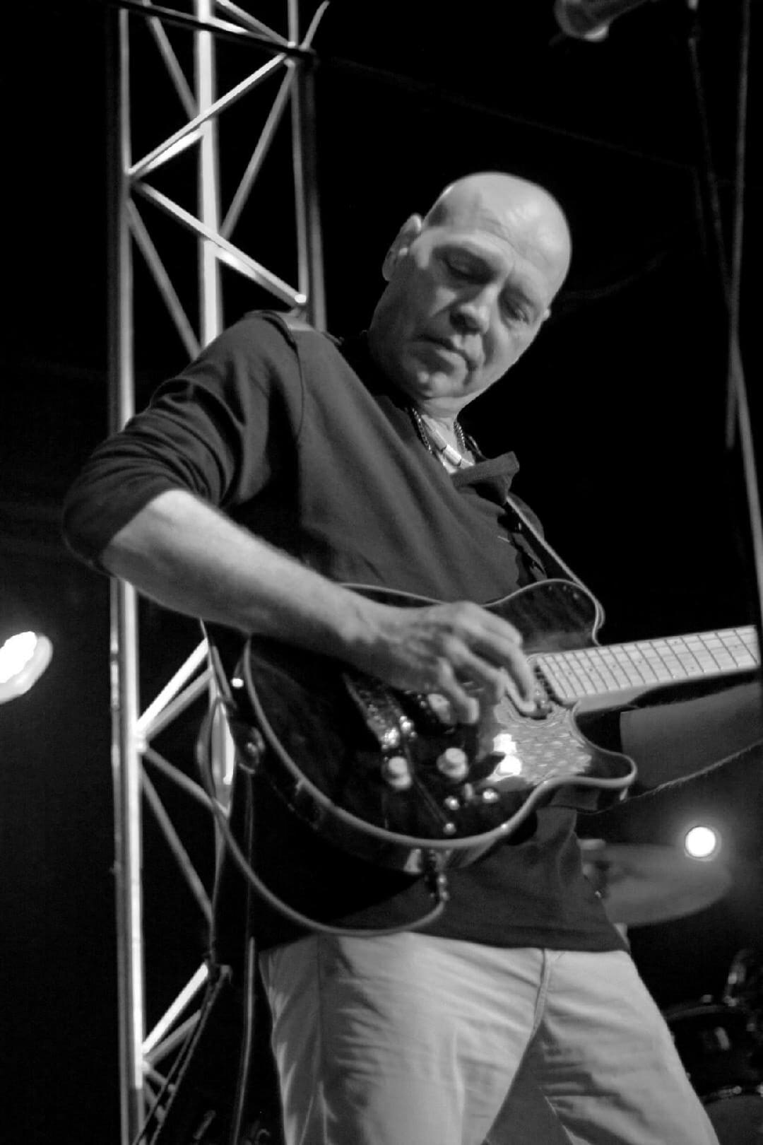 A man playing an electric guitar on stage.