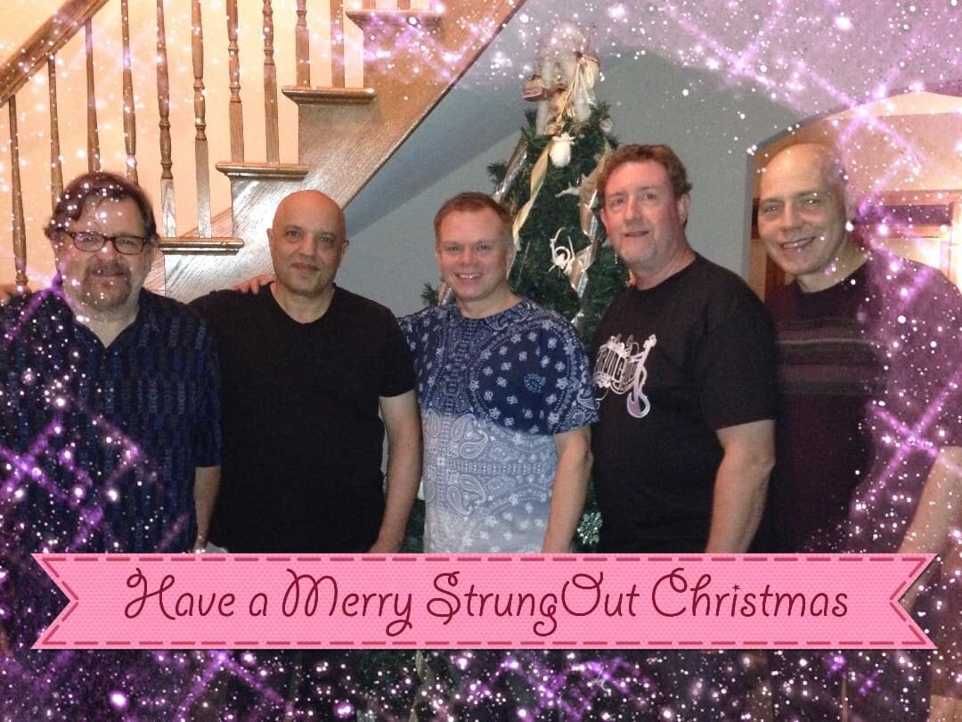 A group of people standing in front of a christmas tree.